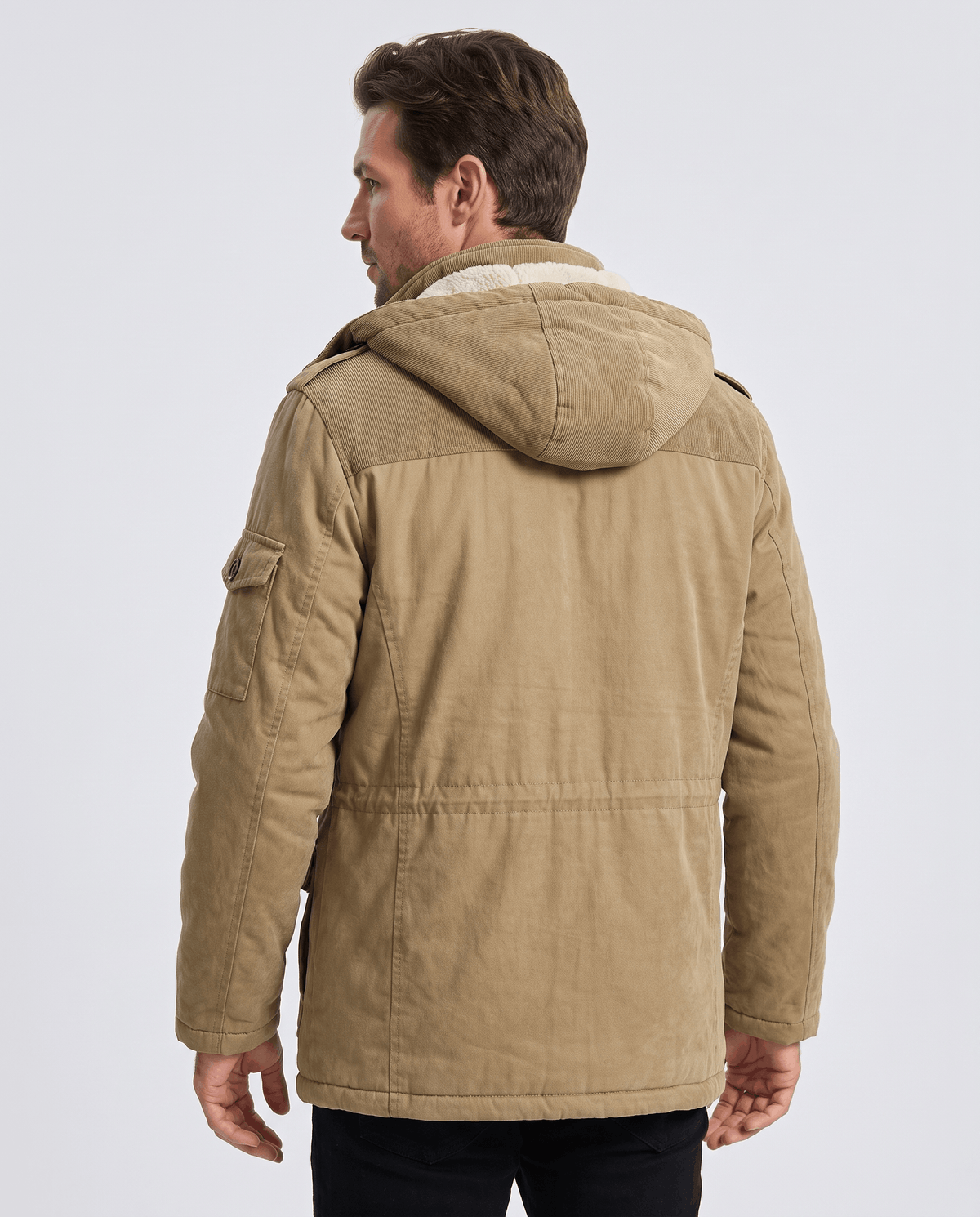 A man wearing a beige fleece-lined parka with a detachable hood and insulated design, shown from the back