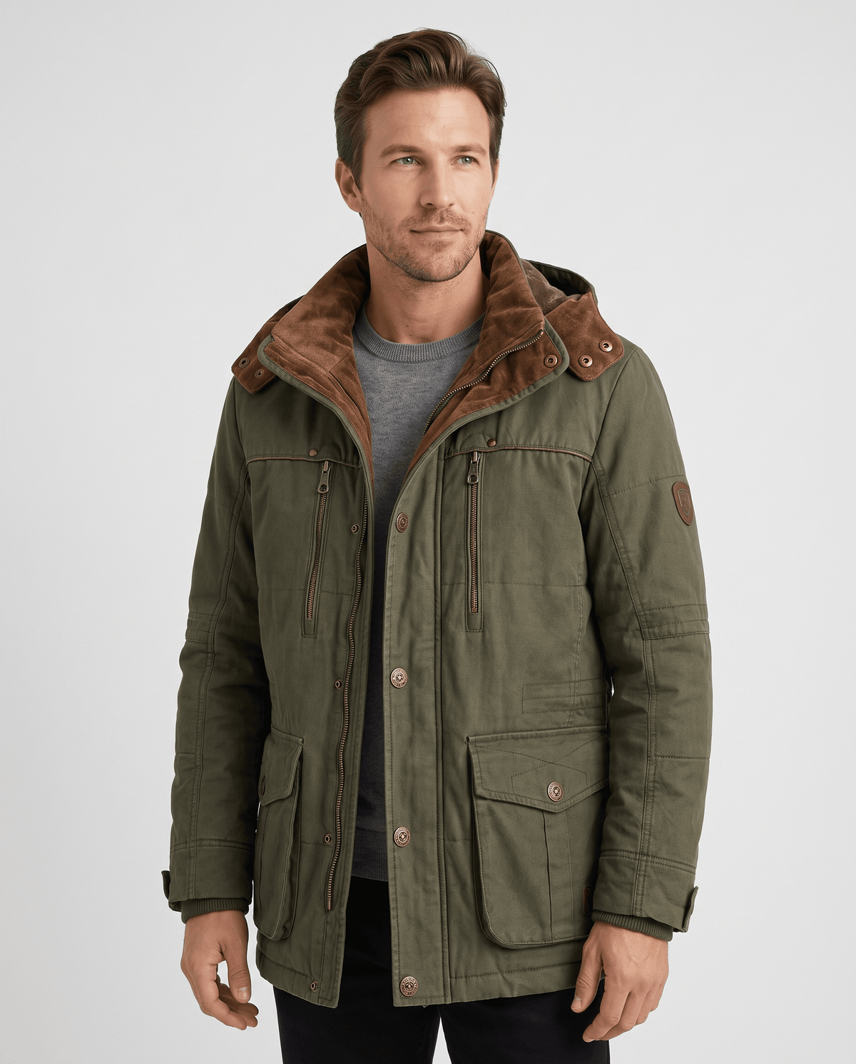 A man wearing an olive green fleece-lined parka with an insulated design, hood, zip front, and weather-resistant outer shell