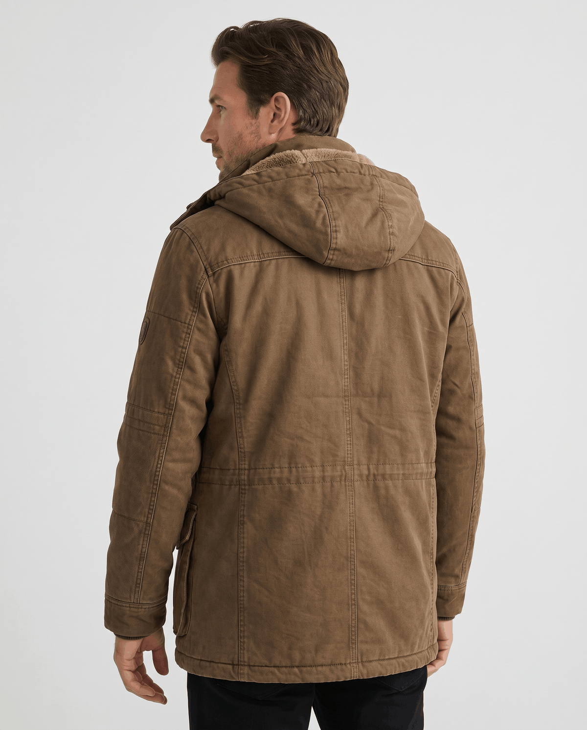 A man wearing a brown fleece-lined parka with an insulated hood and weather-resistant outer shell, back view