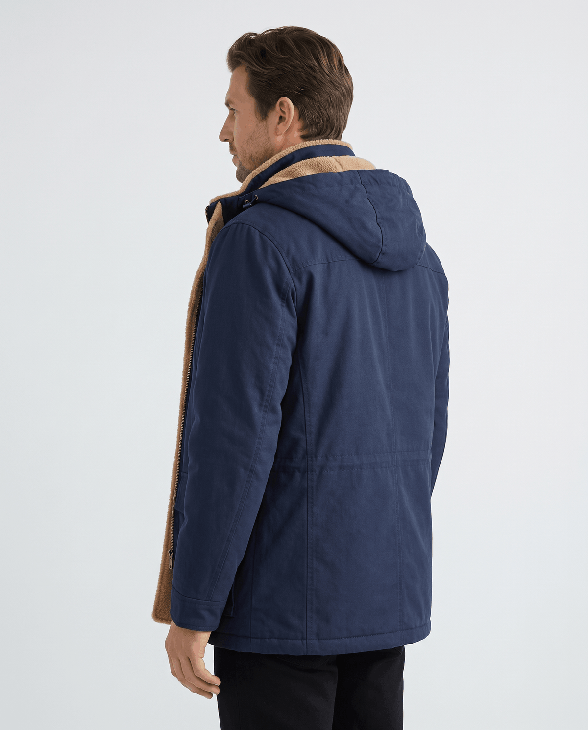A man wearing a navy blue fleece-lined parka with an insulated hood and weather-resistant design, shown from the back