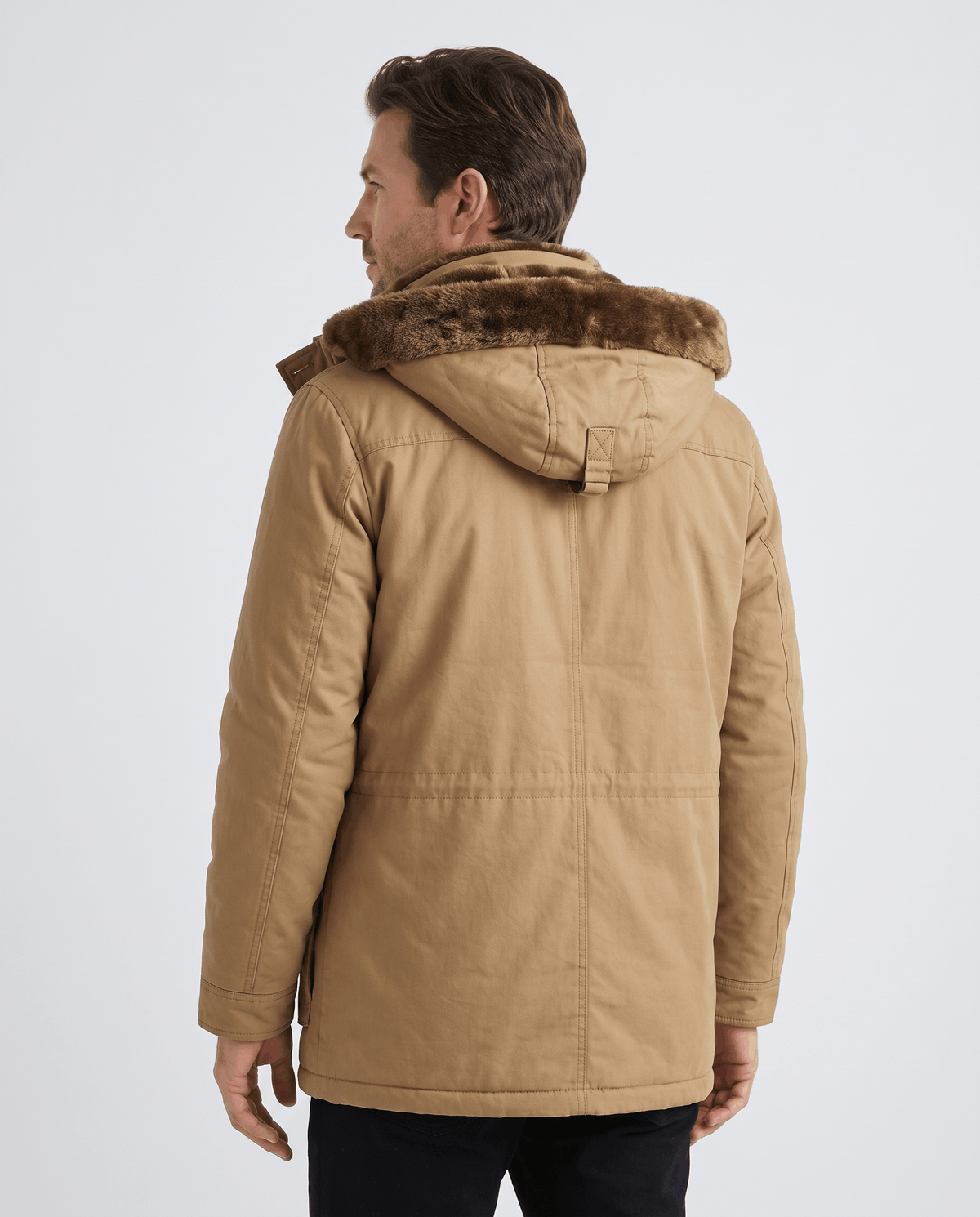 A man wearing a camel fleece-lined parka with an insulated hood and weather-resistant outer shell, back view