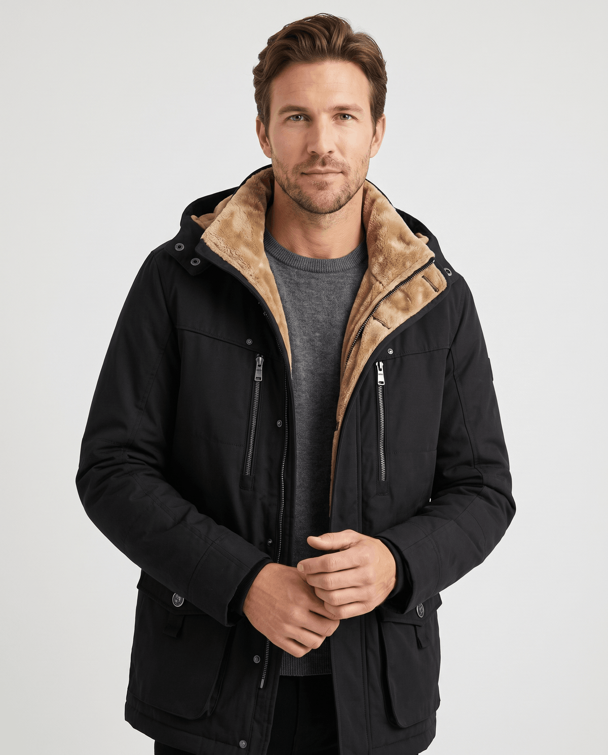 A man wearing a black fleece-lined parka with an insulated hood and zip front
