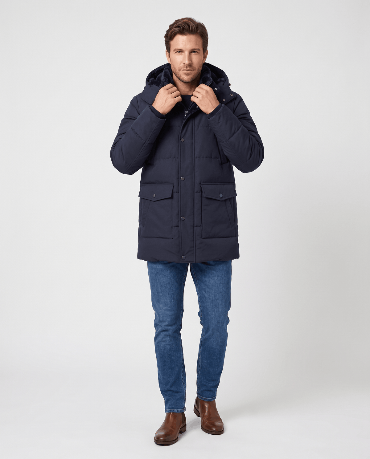 A man wearing a navy blue fleece-lined winter jacket with a hood and full-zip front, adjusting the collar