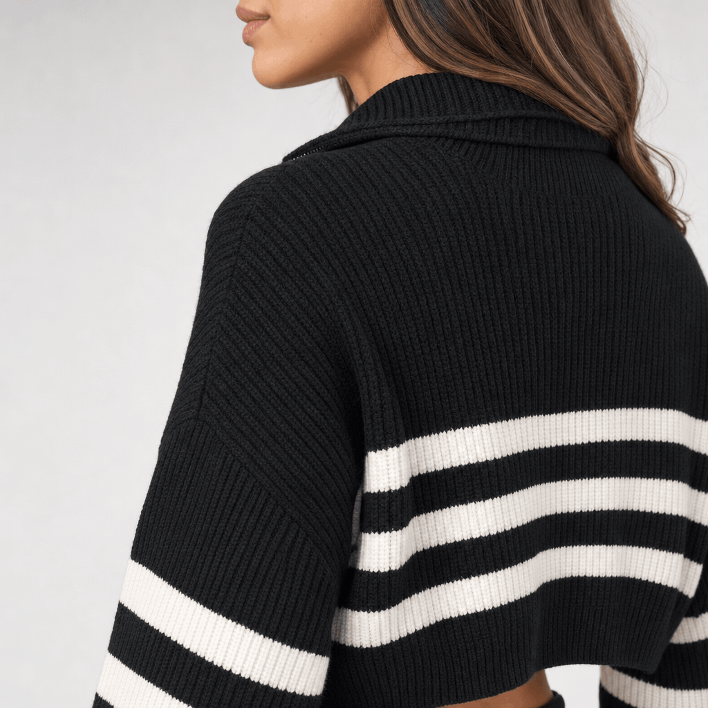 Back and side view of the black sweater, showing the knit texture and white horizontal stripes across the upper back and sleeves.