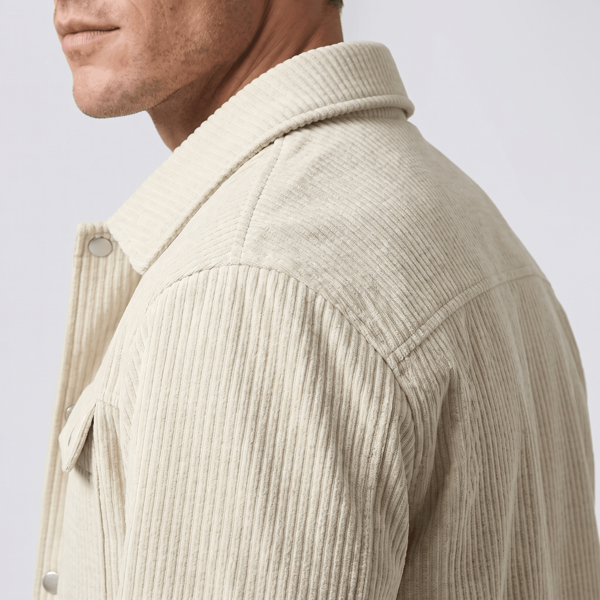 Cream corduroy trucker jacket with a pointed collar, snap-button front, and structured shoulder yoke.