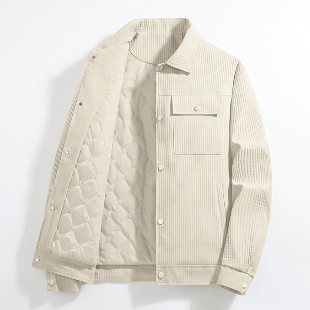 Cream corduroy trucker jacket with a diamond-quilted lining, snap-button front, and dual chest flap pockets.