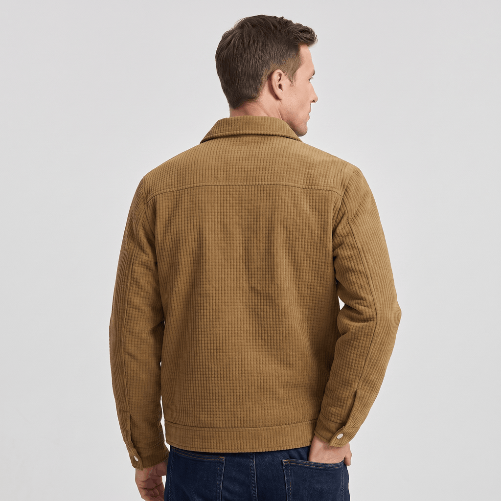 Tan corduroy trucker jacket with a textured finish and classic collar, worn over dark denim jeans from a rear view.