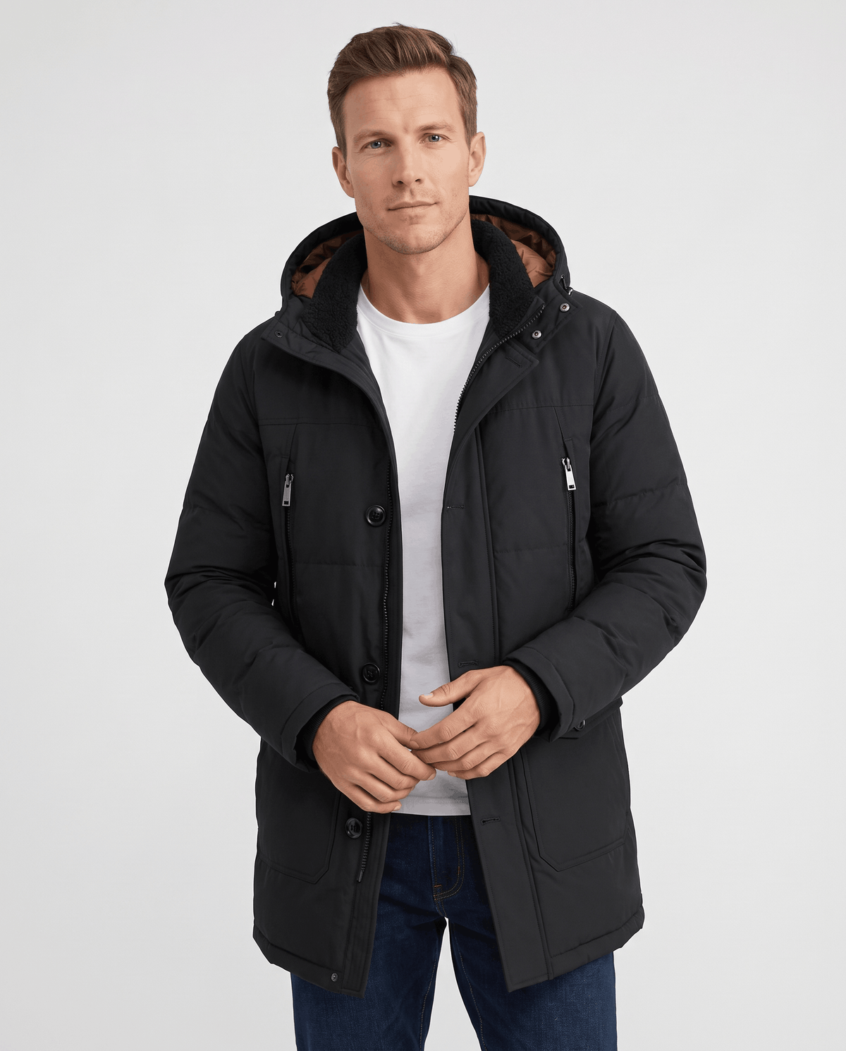 A man wearing a black insulated winter parka with a hood, full-zip front, and multiple utility pockets