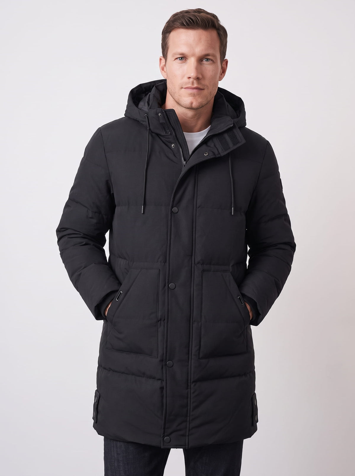 Black hooded quilted winter coat with longline design and front pockets worn by a male model