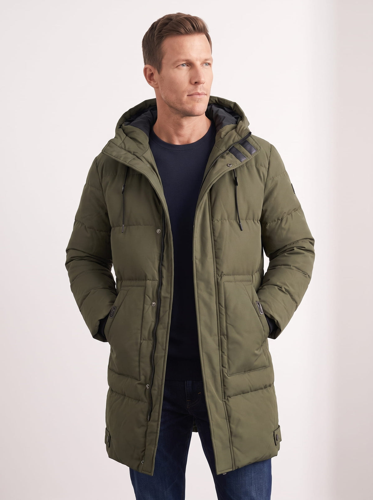 Olive green hooded quilted winter coat with longline design and front pockets worn by a male model