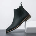 Black Chelsea boot with an elastic side panel, rear pull tab, smooth leather-style upper, and rugged lug sole.