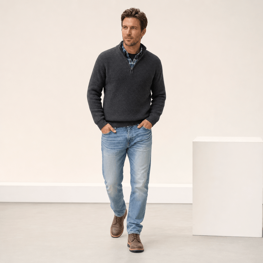 Man wearing the charcoal gray ribbed knit quarter-zip sweater with light blue jeans.