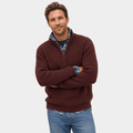 Man wearing a burgundy ribbed knit quarter-zip sweater over a blue shirt, paired with light blue jeans.