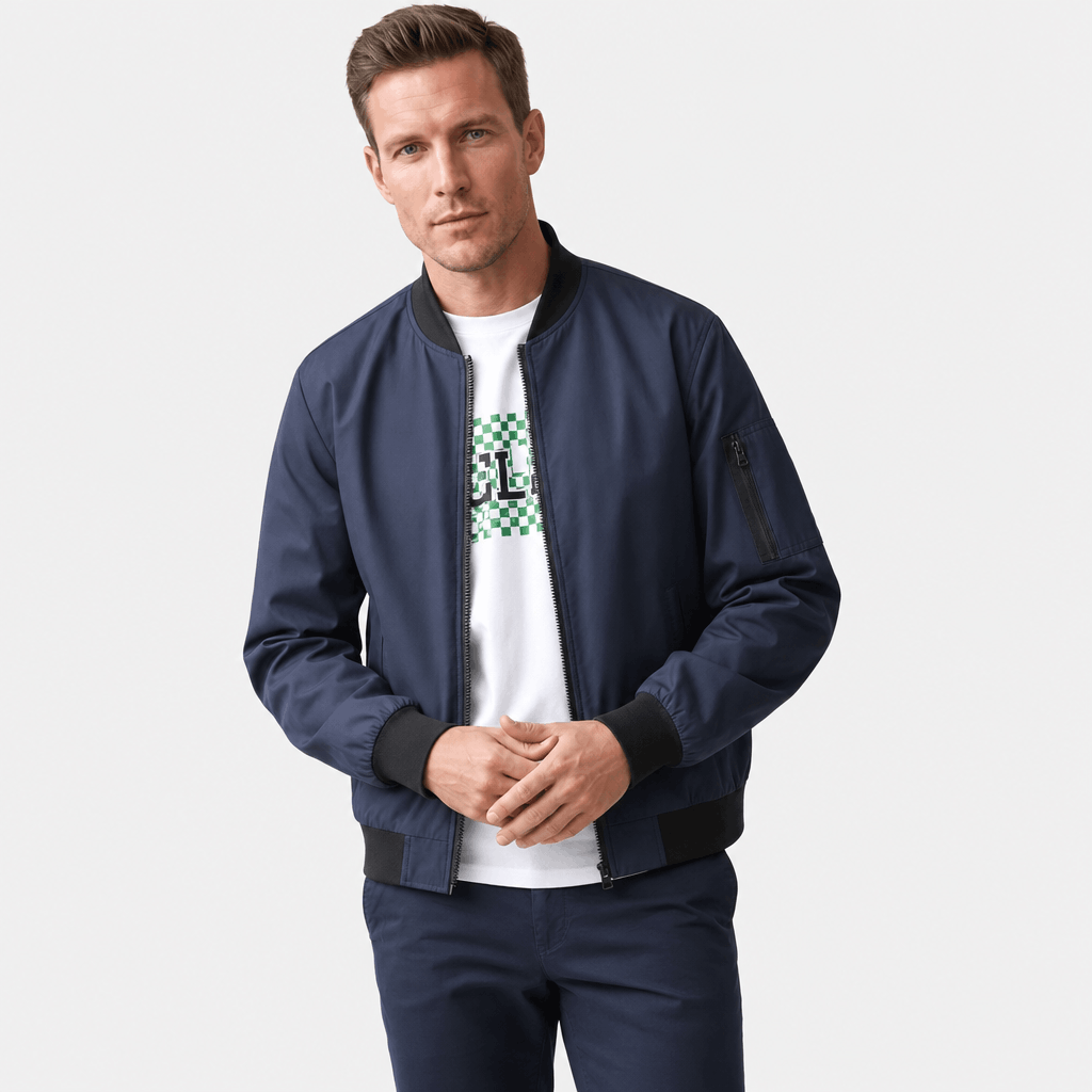 Man wearing a navy blue bomber jacket over a white graphic T-shirt.