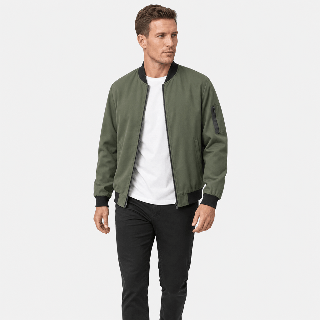 Man wearing an olive green bomber jacket over a white T-shirt and dark trousers.