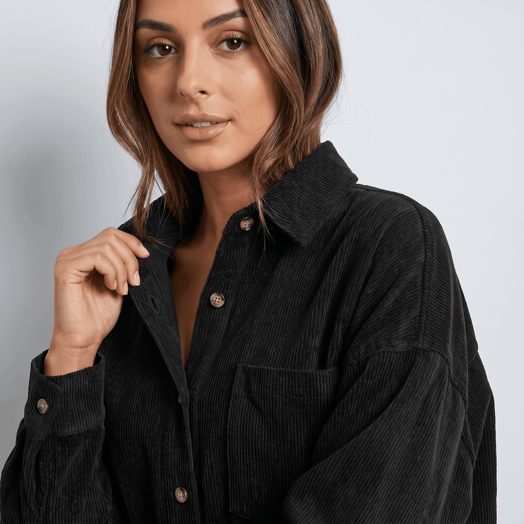 Black corduroy button-down shirt with a point collar, drop shoulders, and a relaxed, oversized fit.