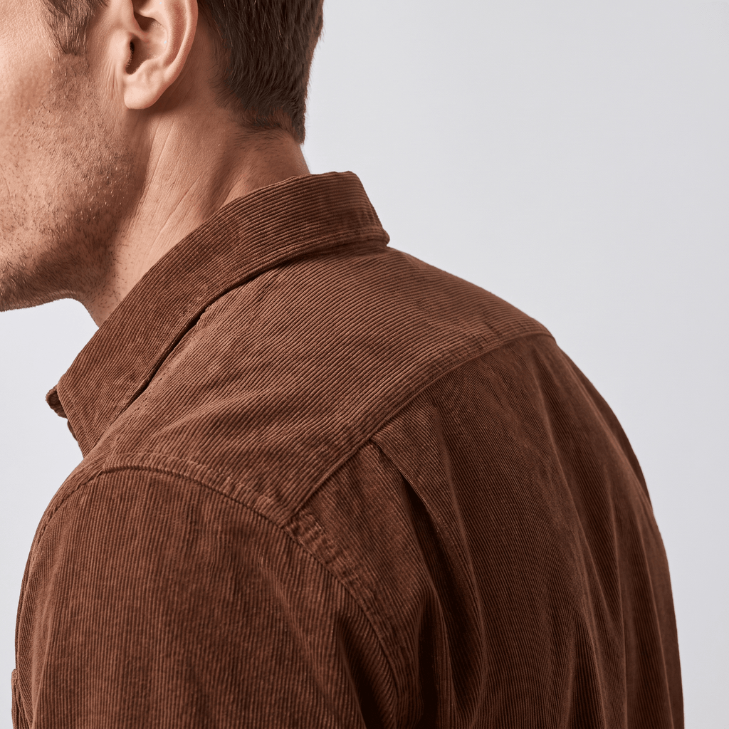 Brown slim-fit corduroy shirt with a clean classic collar and fine-ribbed texture worn in a tailored silhouette.