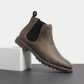 Brown Chelsea boots with elastic side panels, rear pull tabs, smooth suede uppers, and rugged textured rubber soles.