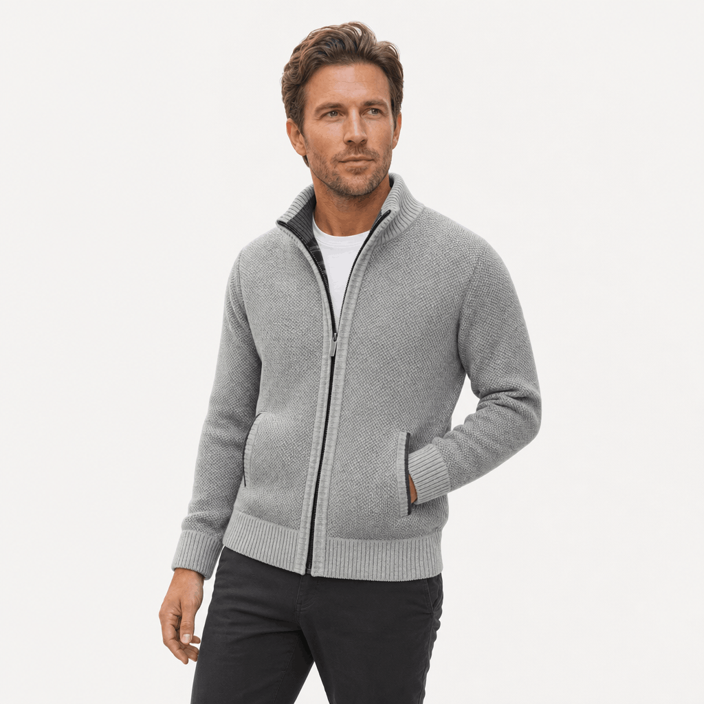 Male model wearing a light gray textured zip-up jacket with hands in the side pockets.