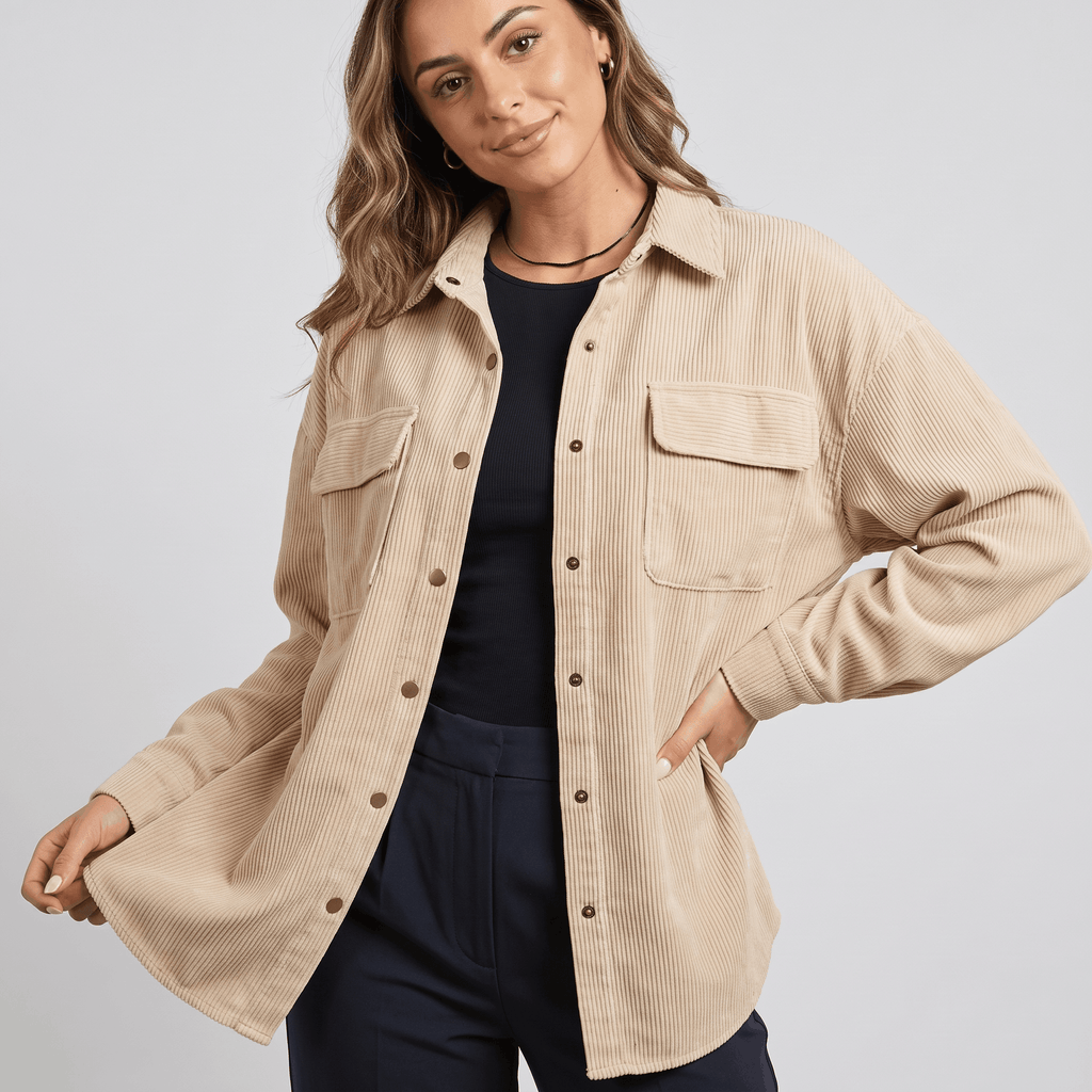 Oversized khaki wide wale corduroy shirt jacket with buttoned chest pockets and a relaxed drop-shoulder fit.
