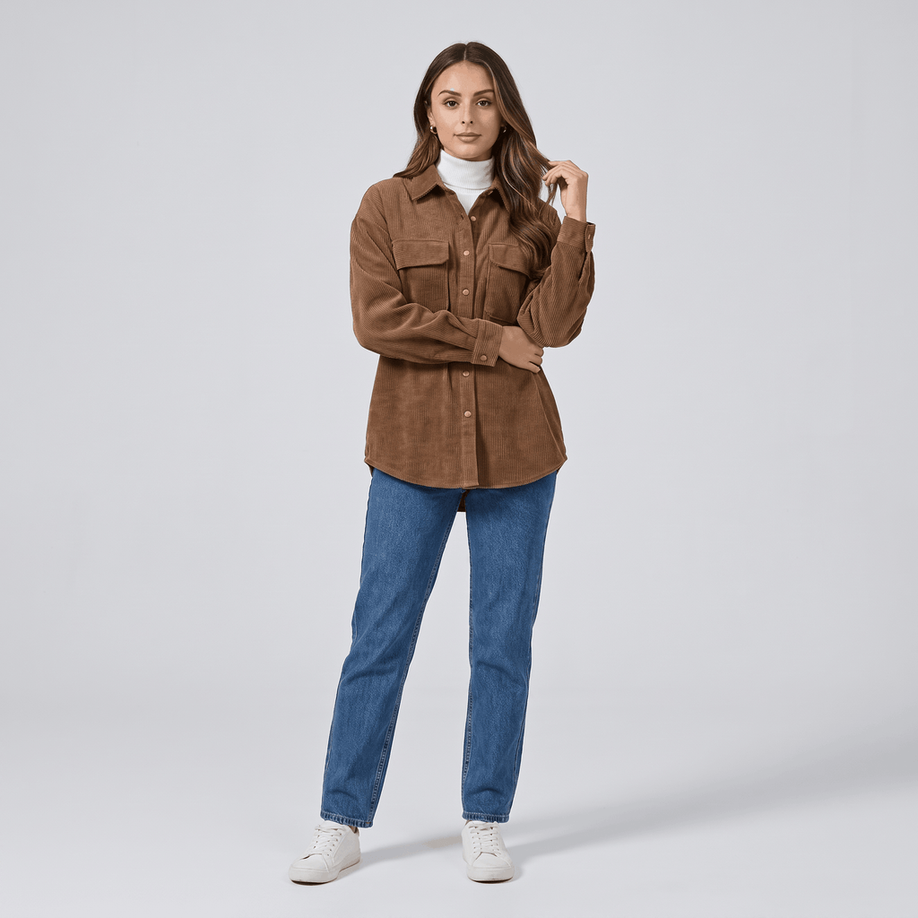 Oversized khaki wide wale corduroy shirt jacket with buttoned chest pockets layered over a white turtleneck.