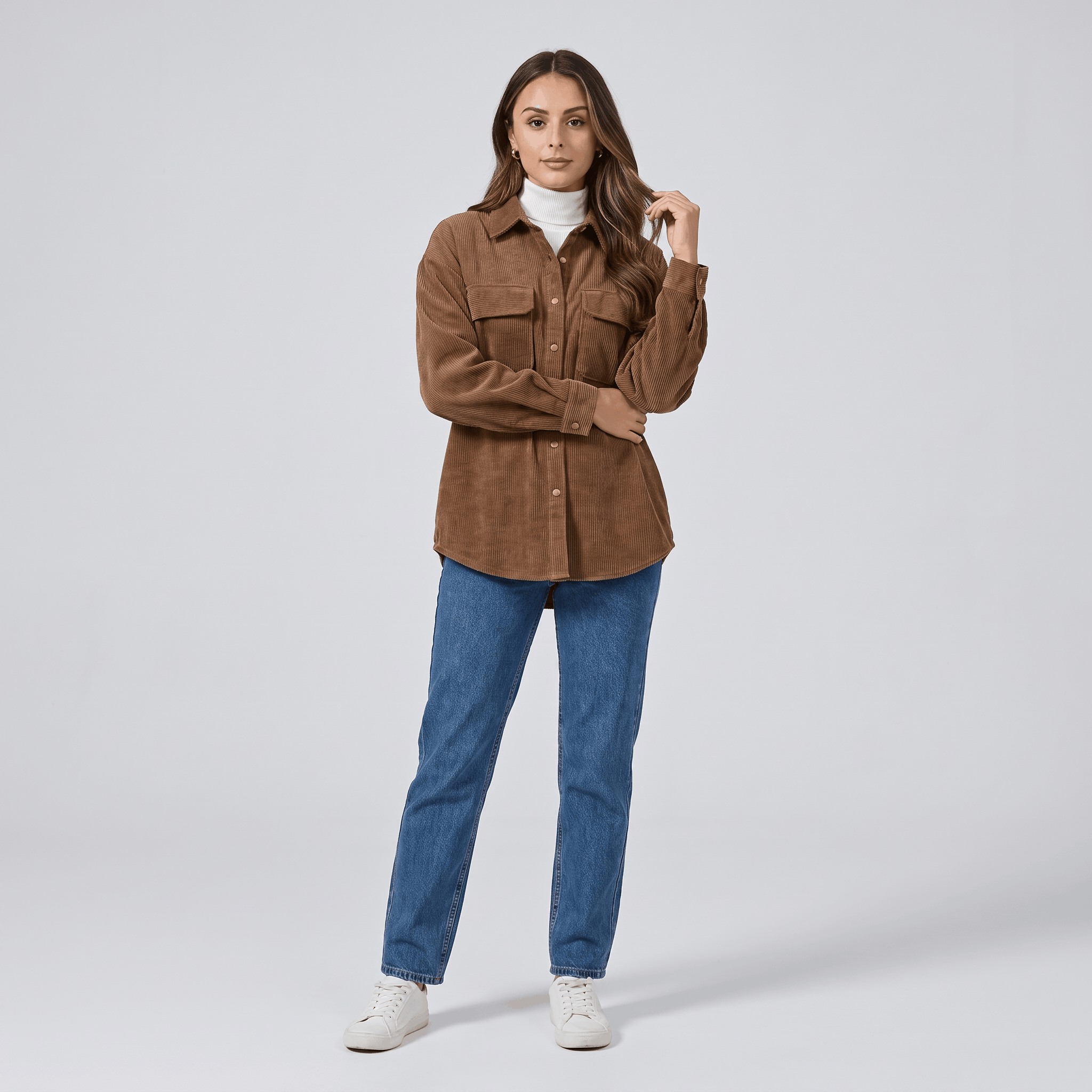 Oversized khaki wide wale corduroy shirt jacket with buttoned chest pockets layered over a white turtleneck.