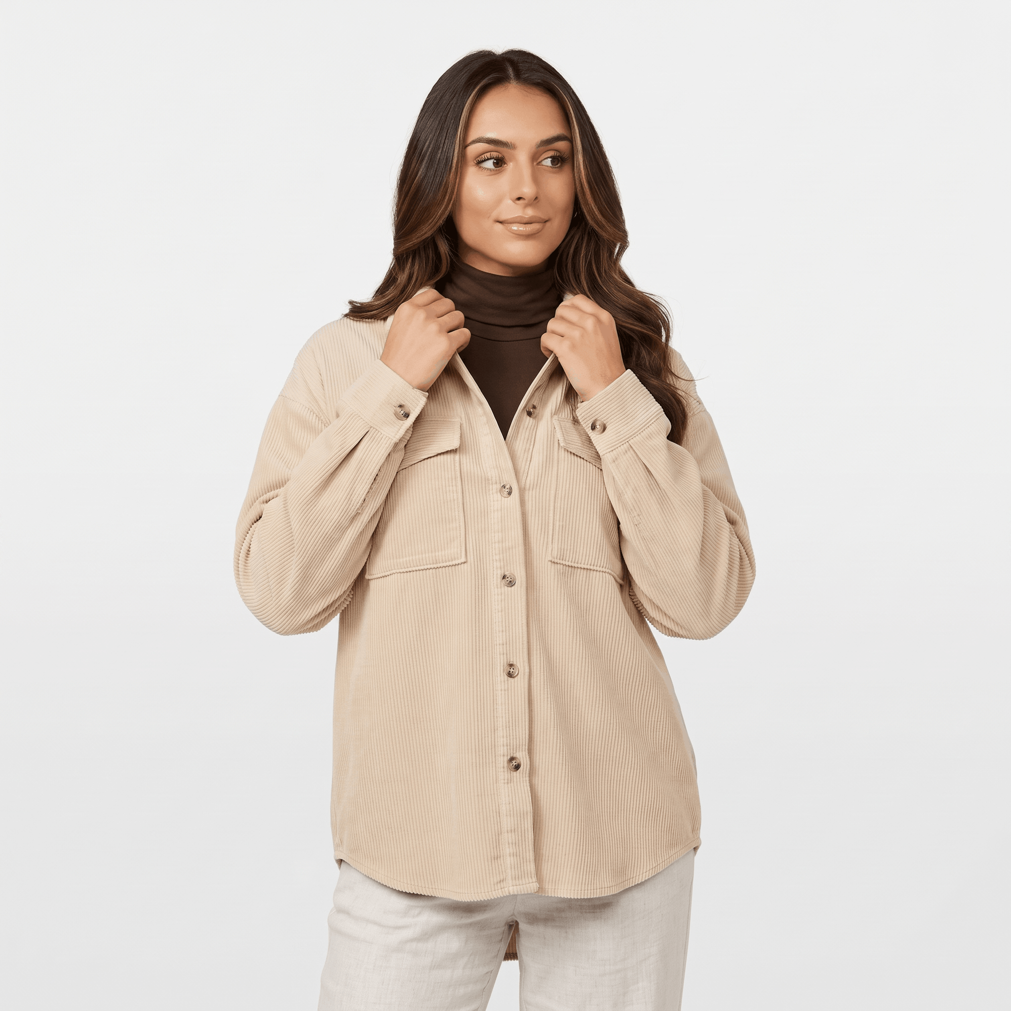 Oversized khaki wide wale corduroy shirt jacket with buttoned chest pockets and dropped shoulders worn over a turtleneck.