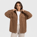 Oversized khaki wide wale corduroy shirt jacket with buttoned chest pockets and dropped shoulders worn open.