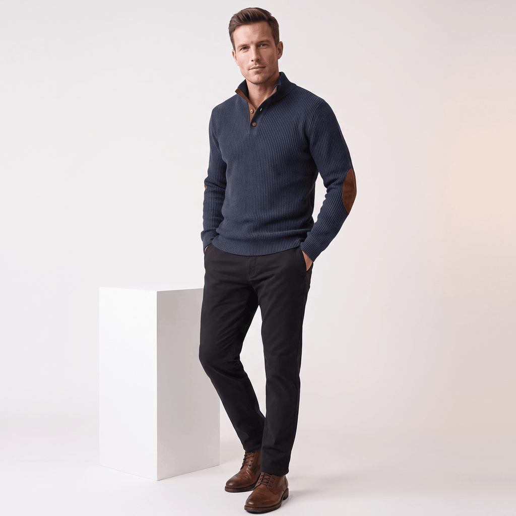 Navy ribbed knit henley sweater with contrast elbow patches, snap stand collar, and relaxed fit worn with dark trousers.