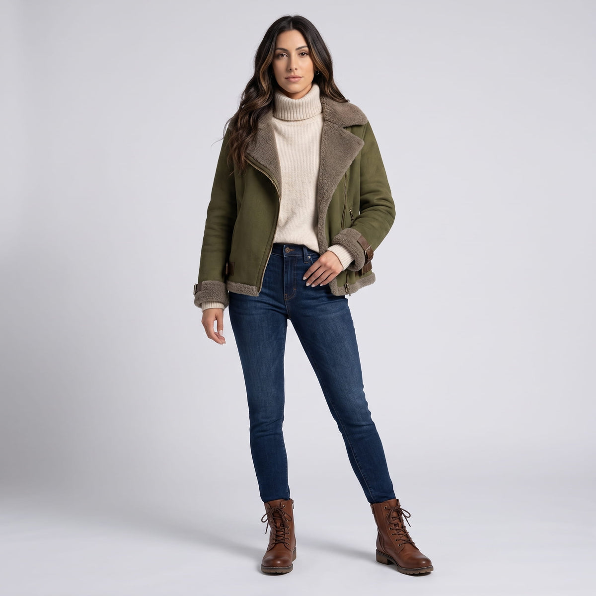 A woman wearing an olive green leather shearling aviator jacket with an asymmetric zip and buckled strap