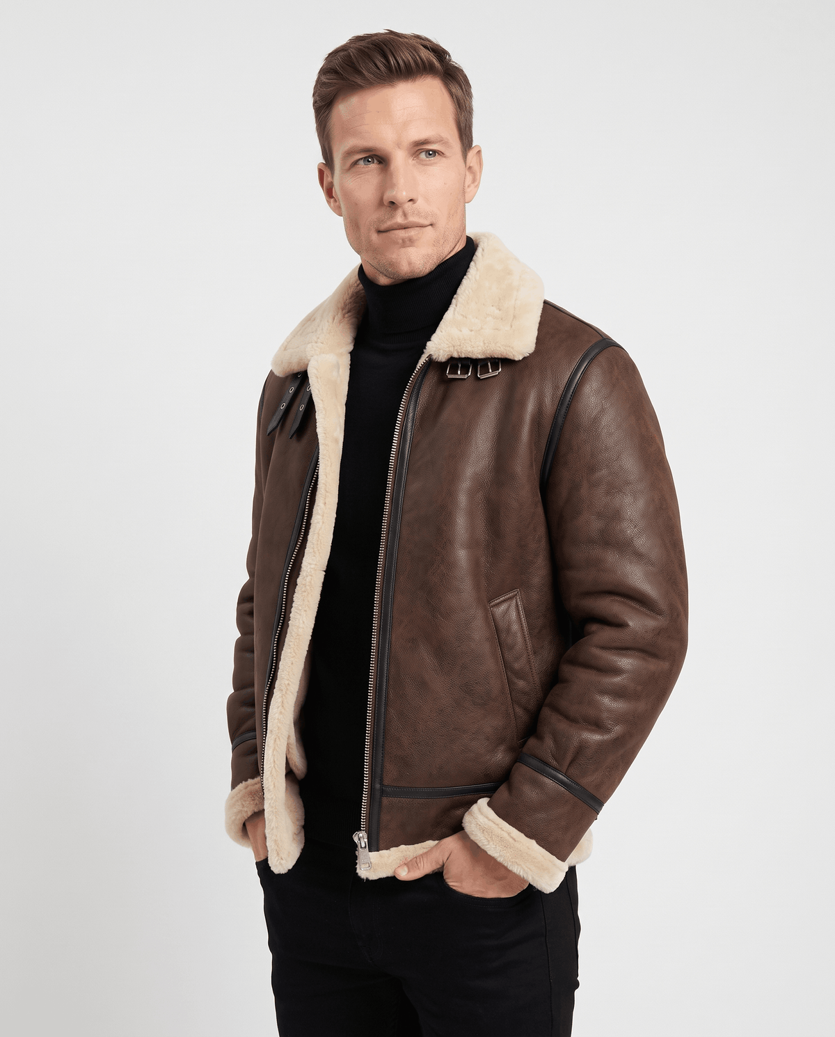 A man wearing a brown leather shearling aviator jacket with a shearling collar, asymmetrical zip, and buckle strap