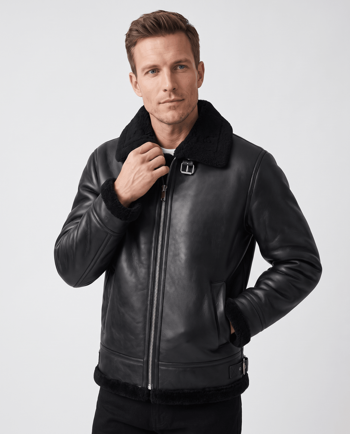 A man wearing a black leather shearling aviator jacket with an asymmetrical zip and buckle strap