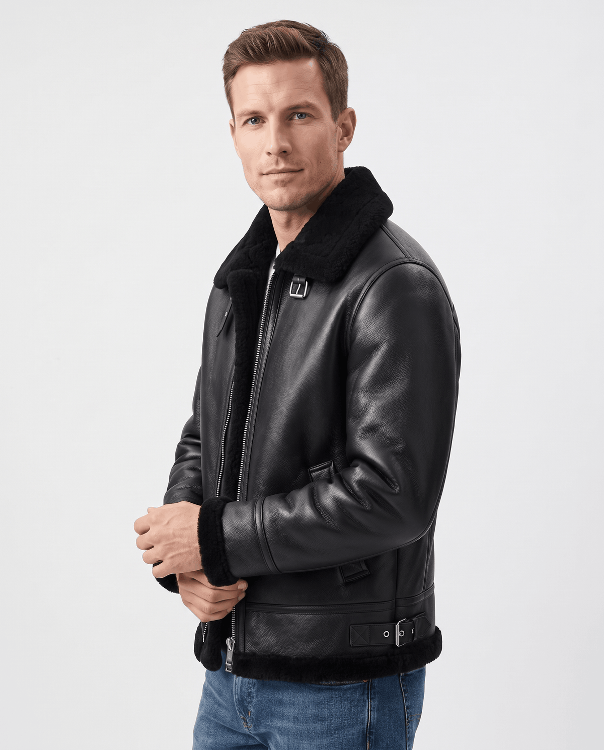 A man wearing a black leather shearling aviator jacket with an asymmetrical zip and buckle strap, shown in side view