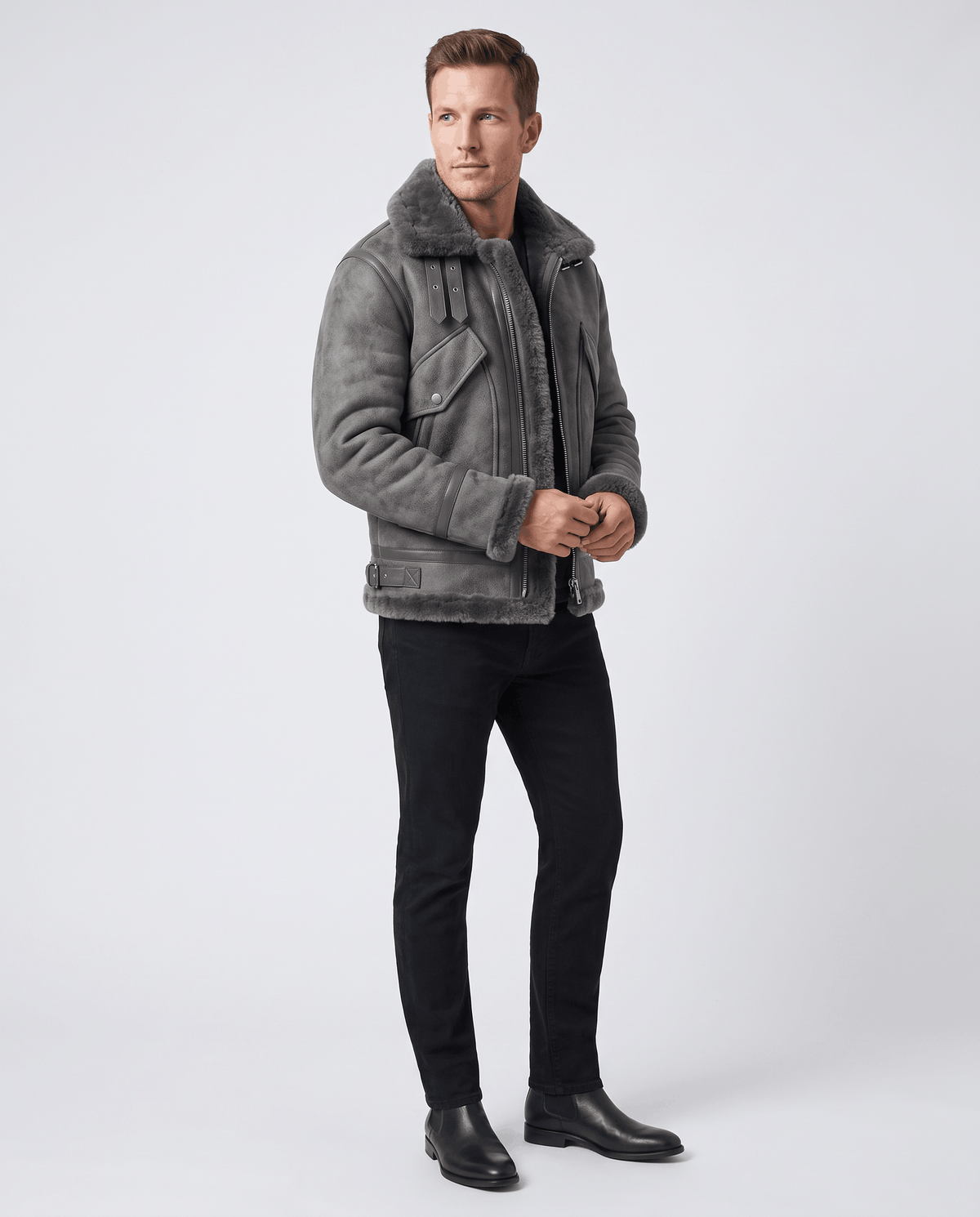 A man wearing a gray leather shearling aviator jacket with a distressed finish and lamb fur lining, full-length view