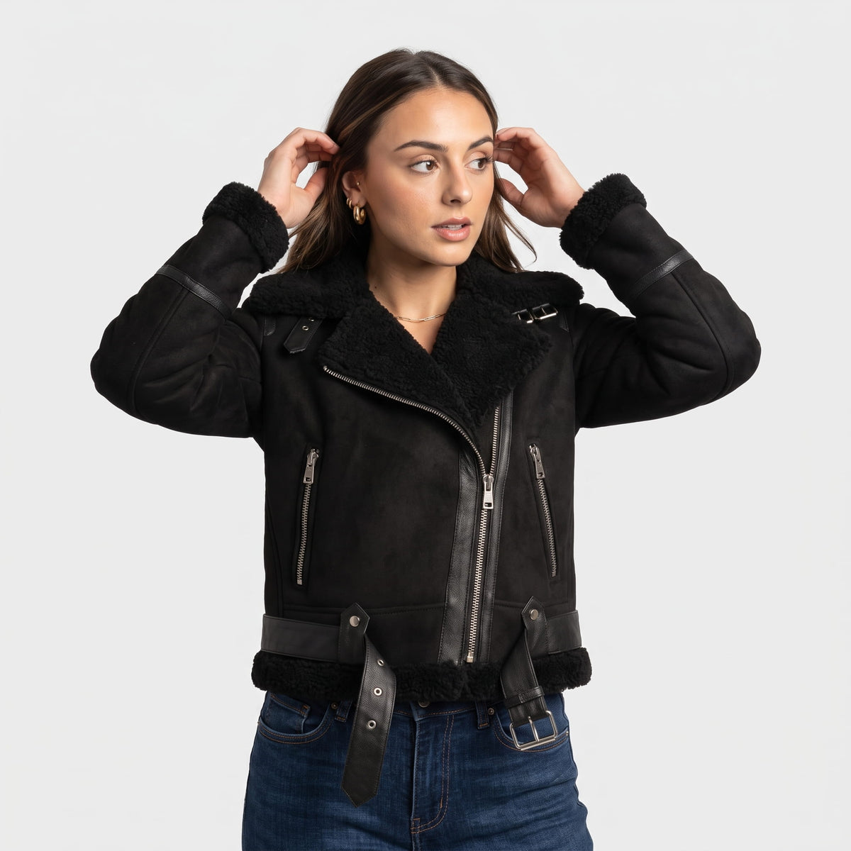 A woman wearing a black leather shearling aviator jacket with an oversized collar, asymmetrical zip, and belted waist
