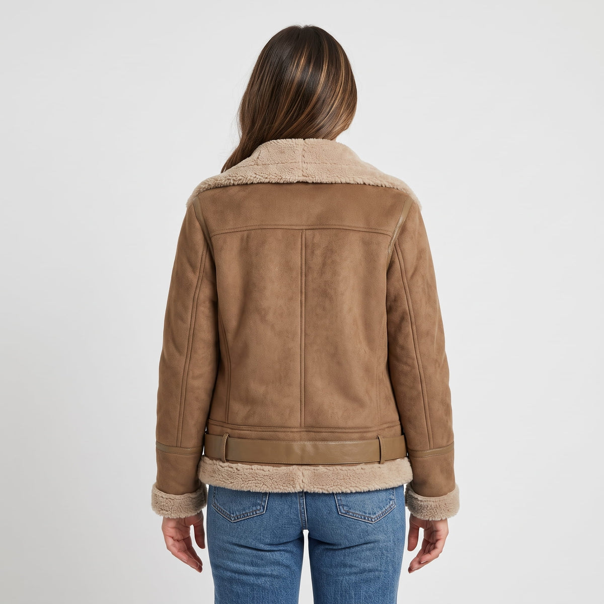 A woman wearing a brown leather shearling aviator jacket with an oversized collar and belted waist, shown from the back