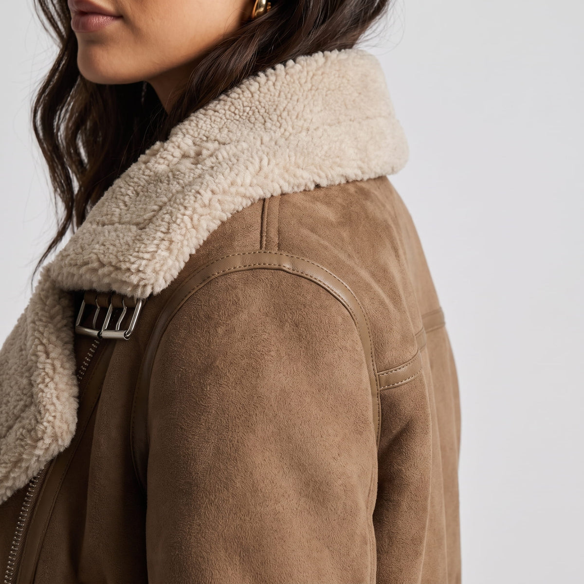 Close-up of a brown leather shearling aviator jacket showing the oversized shearling collar and plush trim