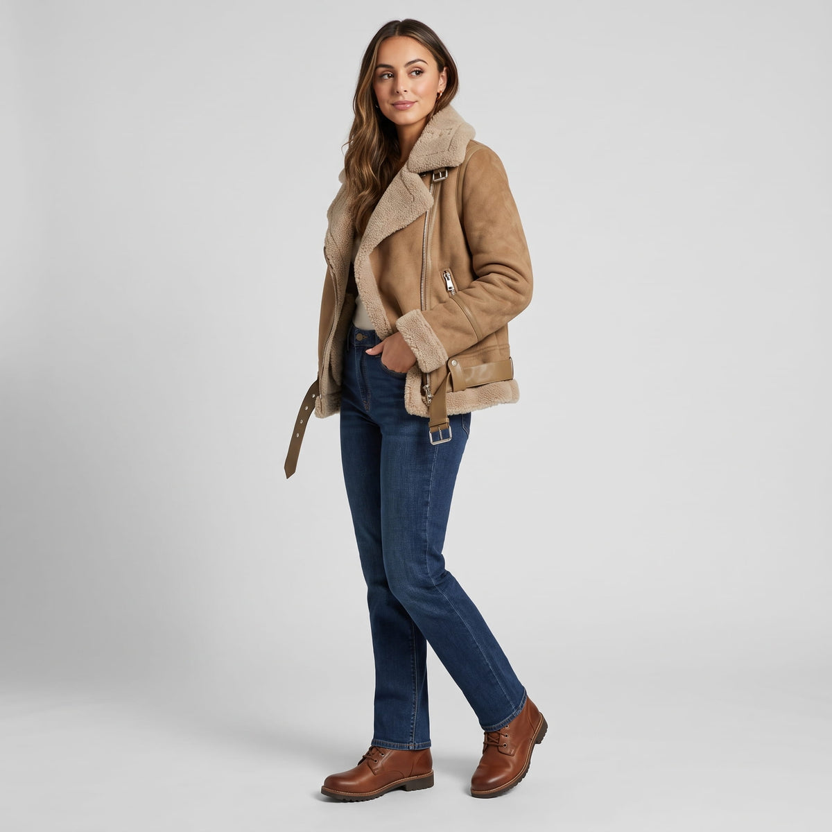 A woman wearing a brown leather shearling aviator jacket with an oversized collar and belted waist, shown in side view