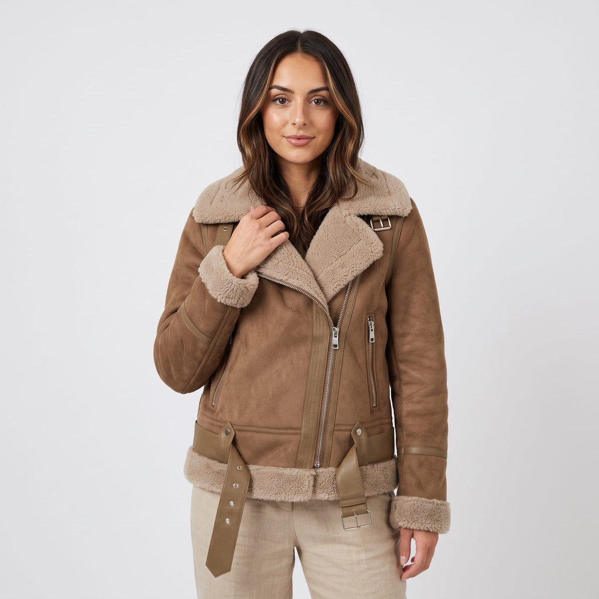 A woman wearing a brown leather shearling aviator jacket with an oversized collar and belted waist
