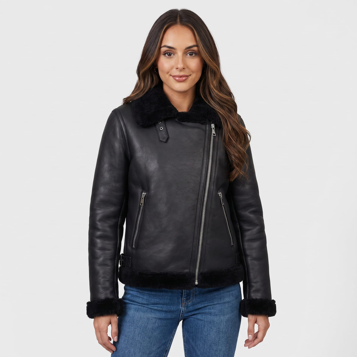A woman wearing a black leather shearling biker jacket with an asymmetrical zip and plush trim