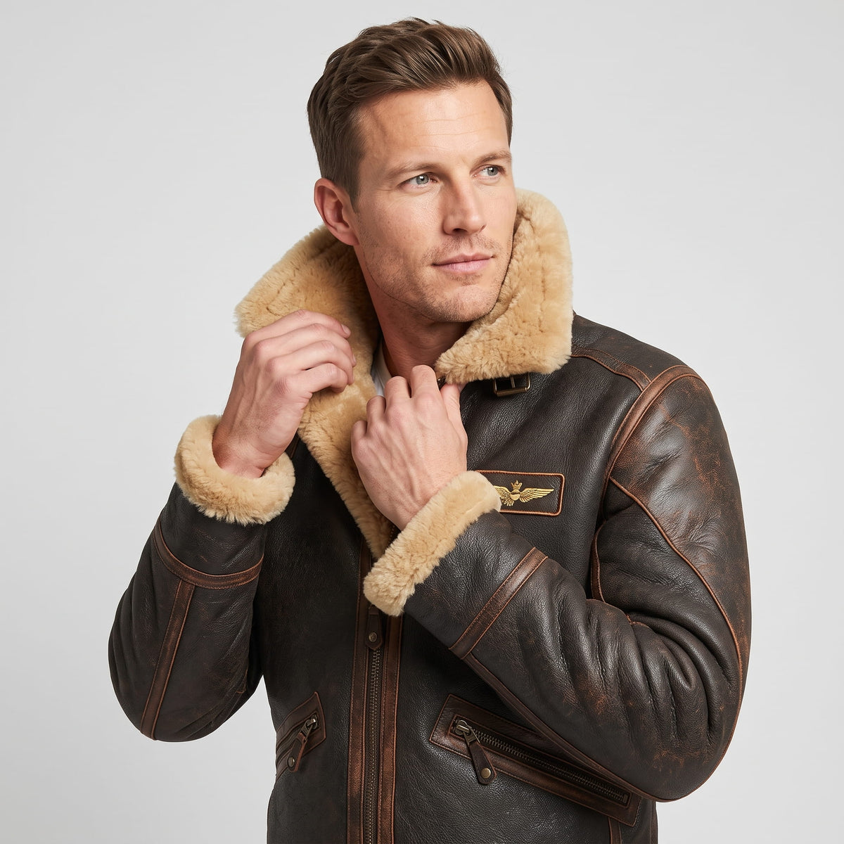 Close-up of a man wearing a dark brown leather shearling bomber jacket, showing the sherpa collar