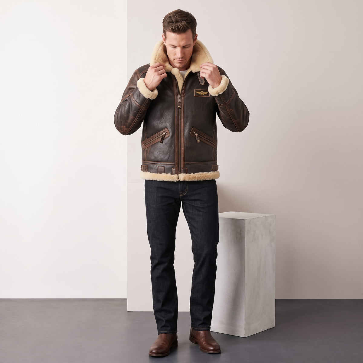 A man wearing a dark brown leather shearling bomber jacket with a sherpa collar, adjusting the front collar