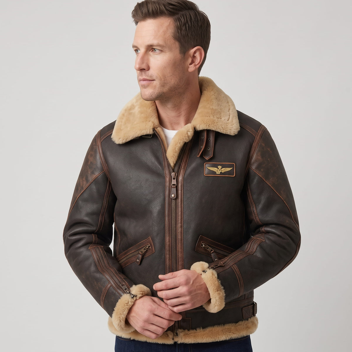 A man wearing a dark brown leather shearling bomber jacket with a sherpa collar and zip pockets