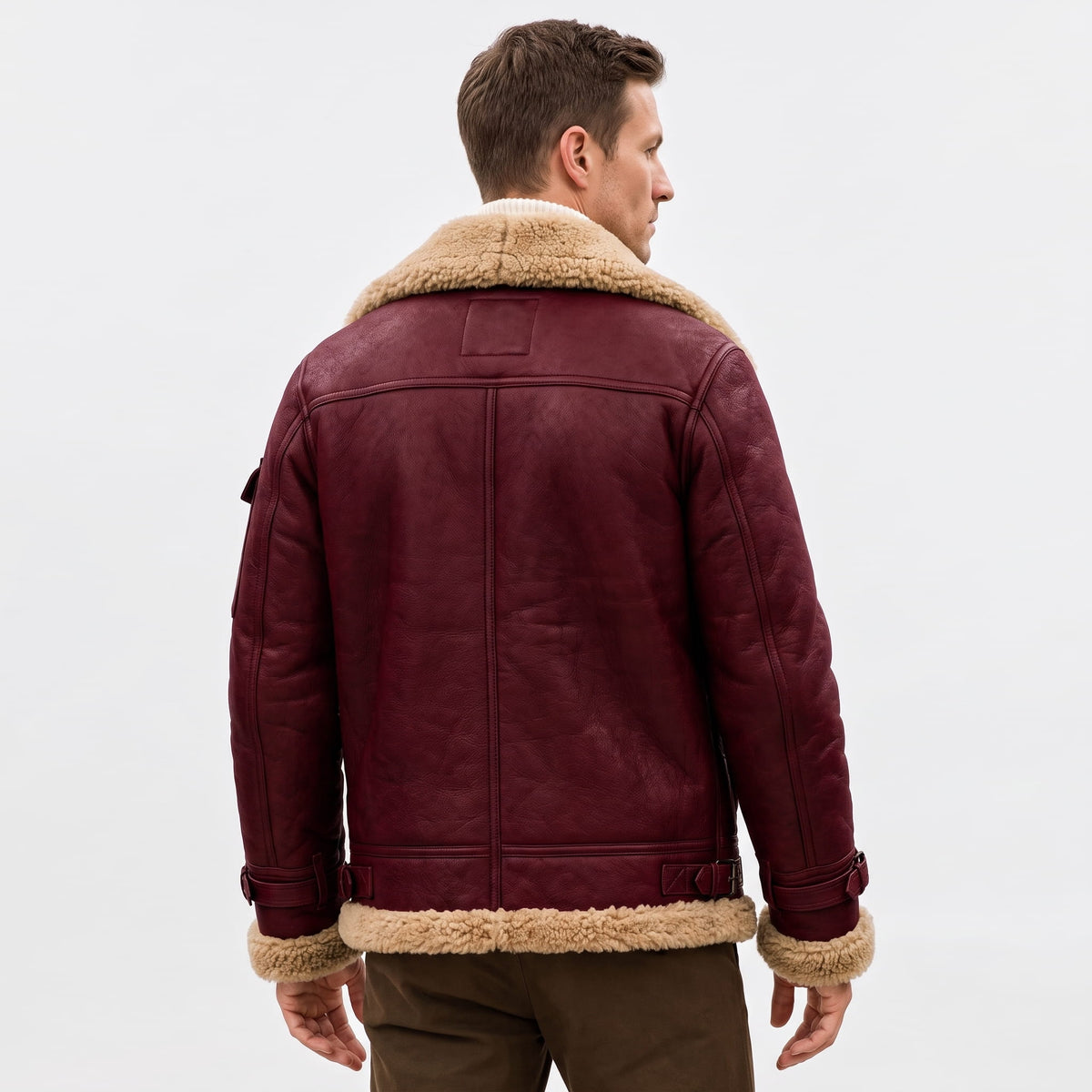 A man wearing a burgundy leather shearling bomber jacket with a sherpa collar, shown from the back