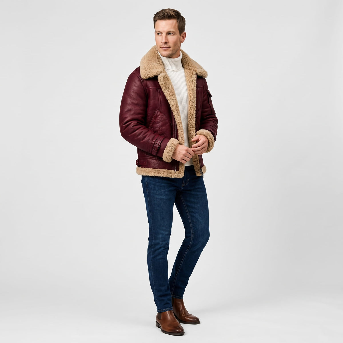 A man wearing a burgundy leather shearling bomber jacket with a sherpa collar and zip pockets, full-length view
