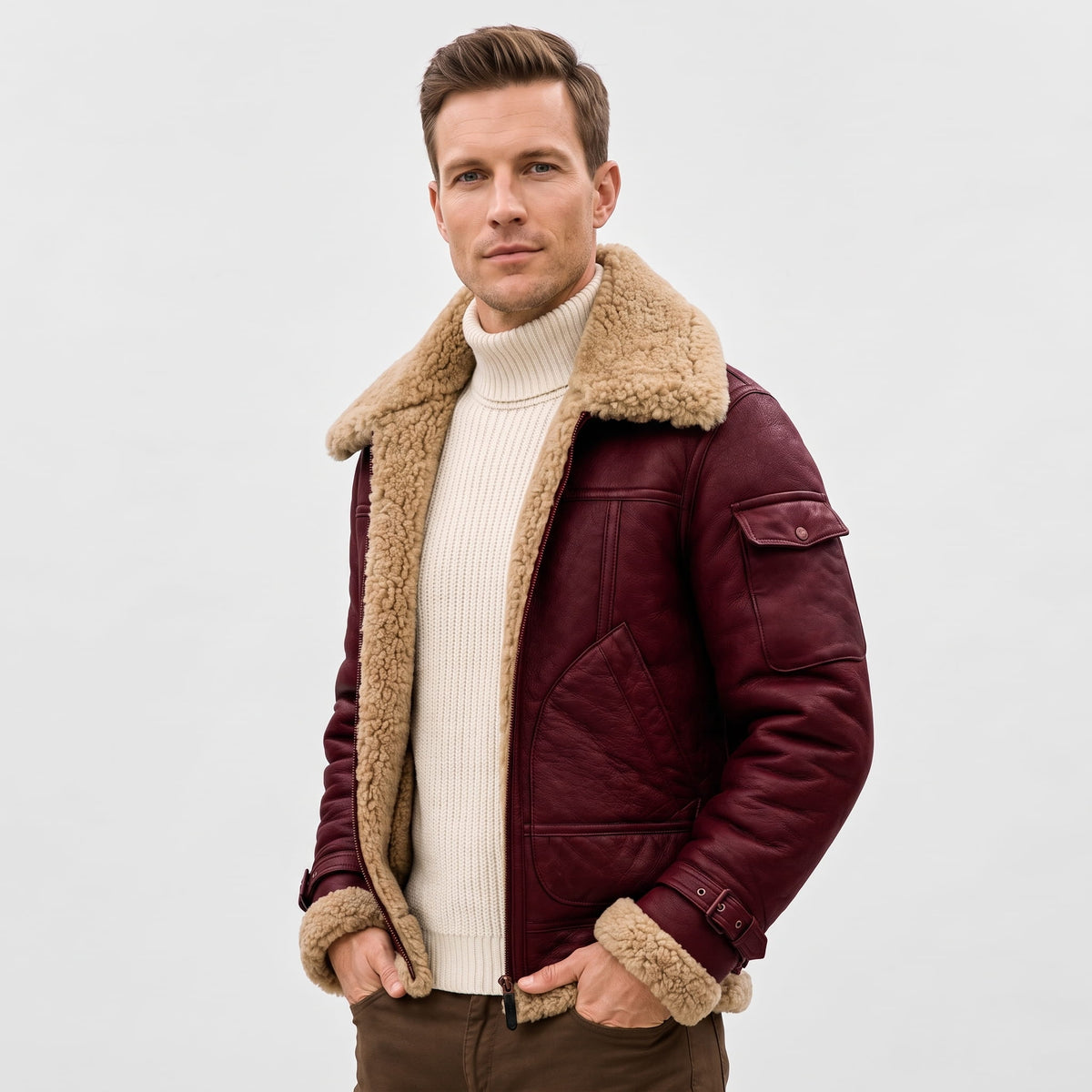 A man wearing a burgundy leather shearling bomber jacket with a sherpa collar and zip pockets, front view