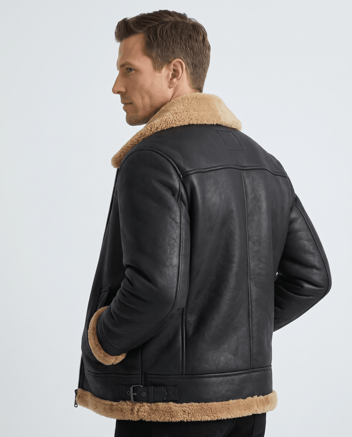 A man wearing a black leather shearling jacket with fur lining and utility pockets, shown from the back