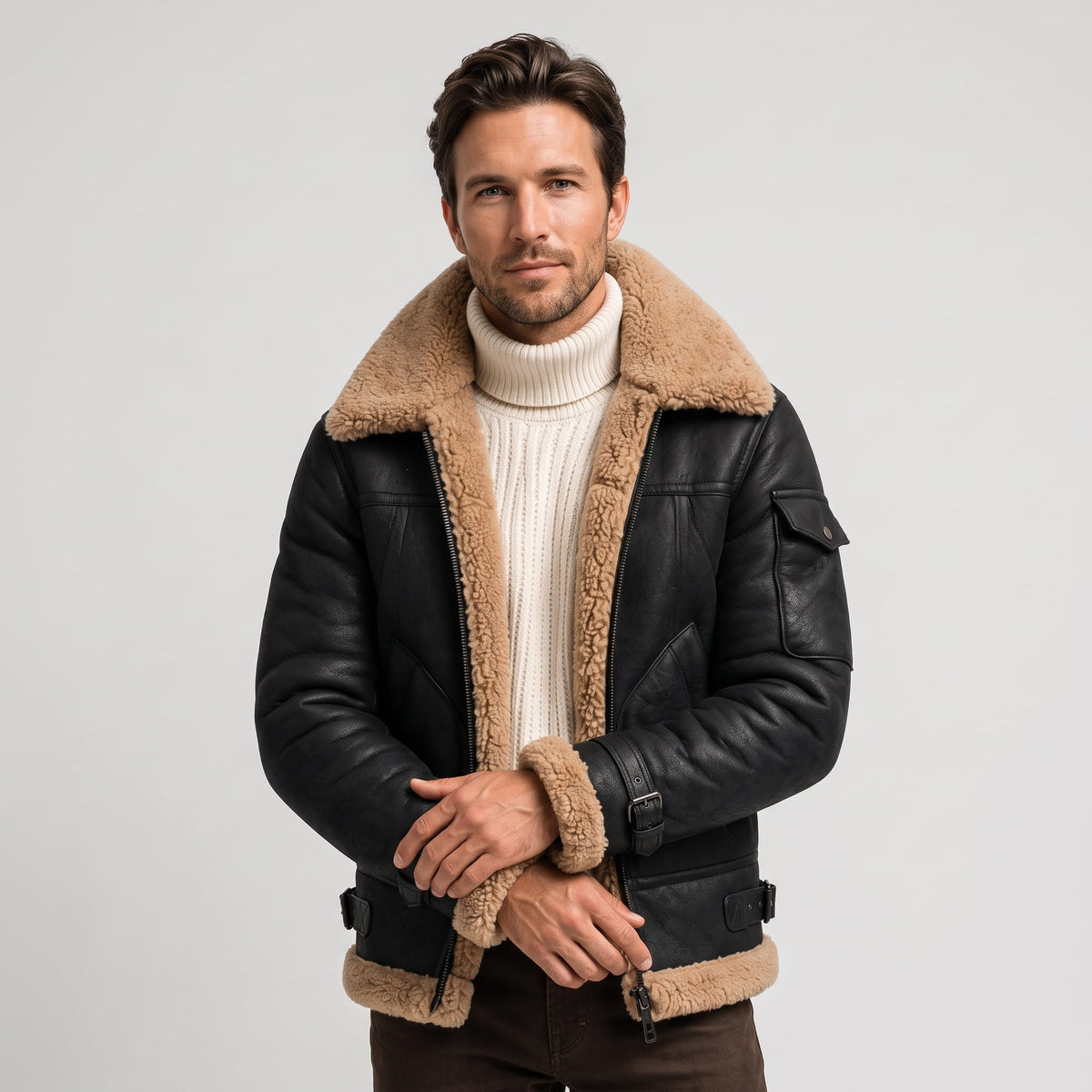 A man wearing a black leather shearling jacket with fur lining and utility pockets, front view