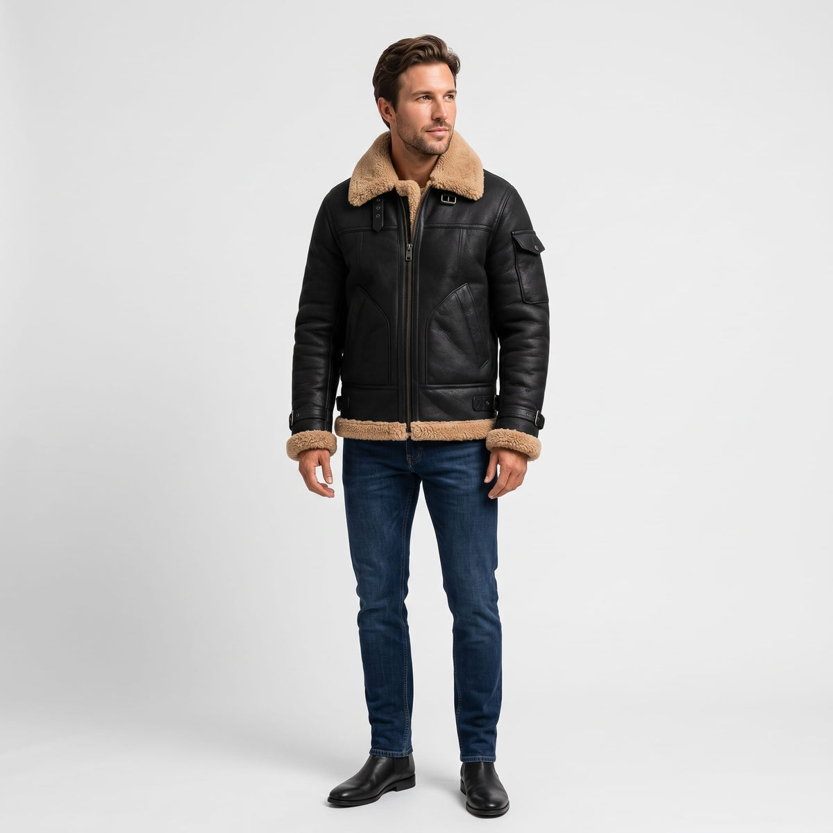 A man wearing a black leather shearling jacket with fur lining and utility pockets, full-length view
