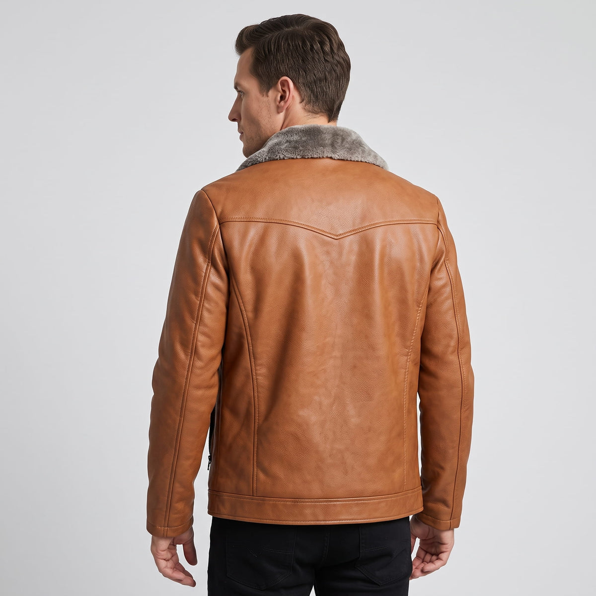 A man wearing a brown leather shearling jacket with a plush collar, shown from the back